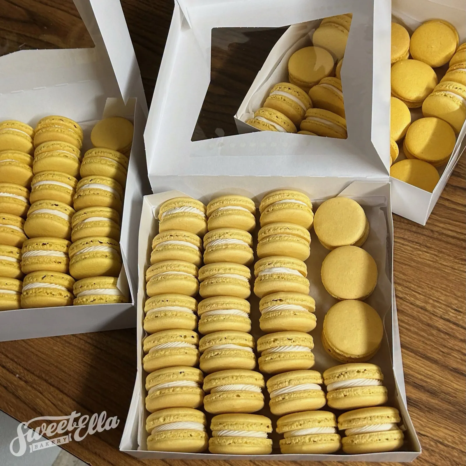 Yellow macarons packed in white bakery boxes